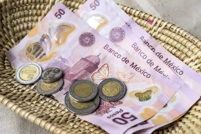 Mexican peso banknotes and coins on a woven basket texture